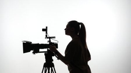 Silhouette of Woman Operating Professional Video Camera on Set