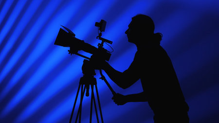 Silhouette of a Camera Operator in Blue Backdrop