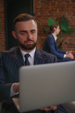Professional Business Meeting with Focused Man on Laptop