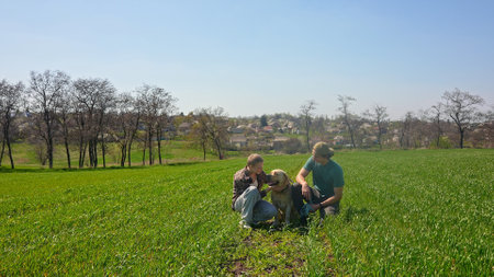 Two Friends Enjoy Relaxing Outdoors with a Dog in a Green Field