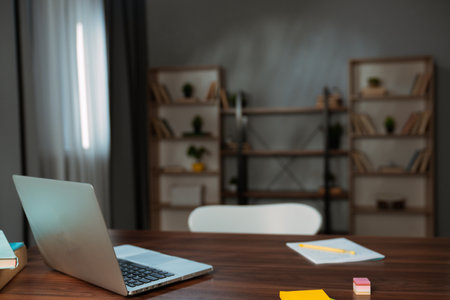 Modern Workspace with Laptop and Wooden Bookshelvesの写真素材