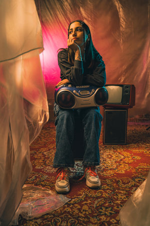 Contemplative Woman Posing with Retro Electronics and Colorful Background