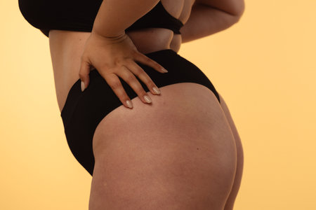 Detailed View of a Woman's Hip and Buttocks on Neutral Background