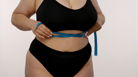Woman Measuring Waist with Tape for Fitness Progress Tracking