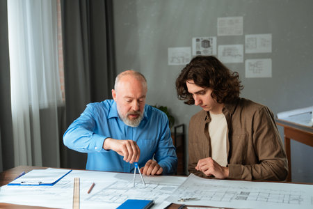 Experienced Architect and Young Apprentice Collaborating on Projectの写真素材