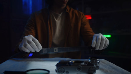 Person with Gloves Handling Film Strip in Photography Studioの写真素材