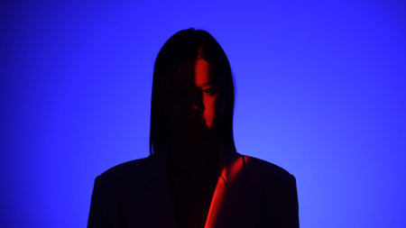 Mysterious Person in Dramatic Blue and Red Lighting Effectの写真素材