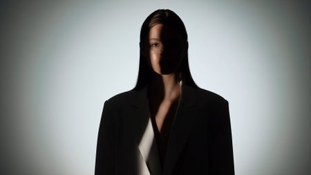 Dramatic Portrait of Woman in Shadow and Light Beamの写真素材