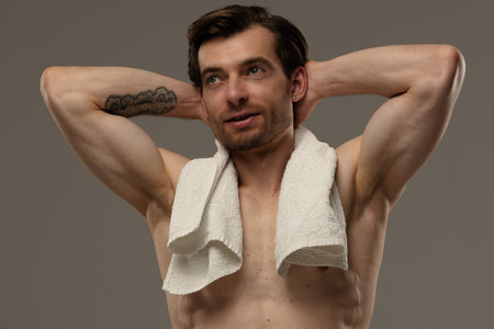 Muscular Man Posing on a Beige Backgroundの写真素材