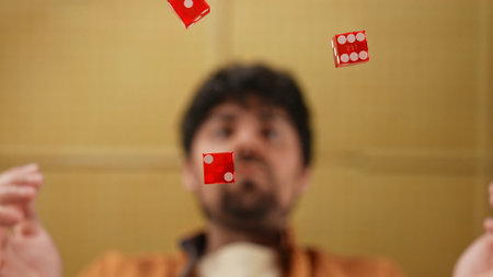 Man Watching Red Dice Fall in Front Below the Glass Table