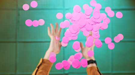 Joyful Moment Captured with Falling Pink Confetti Below the Glass Table