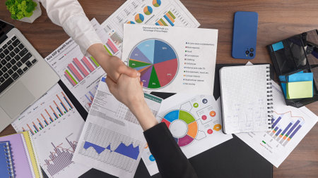 Business Handshake Over Financial Documents and Chartsの写真素材