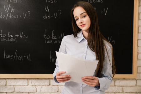 Young Woman Standing in Classroom with Chalkboard