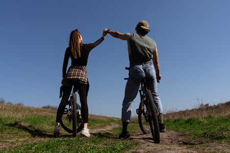 Couple on Bicycles High Five on a Sunny Field Trailの写真素材