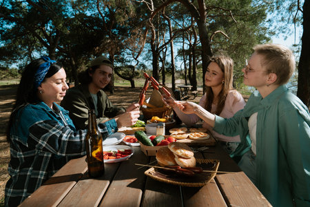 Friends Enjoy Outdoor Picnic in Sunny Forest Settingの写真素材