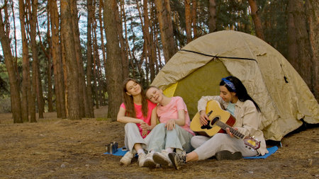 Group of Friends Enjoying Music at Forest Campsiteの写真素材