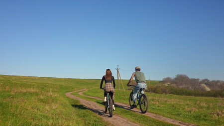 Couple Enjoys Tranquil Cycling Adventure on Rural Trailの写真素材