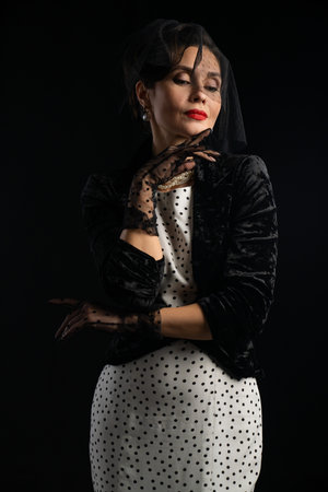 Elegant Lady in Vintage Outfit with Veil and Polka Dotsの写真素材