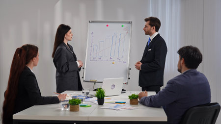 Business Professionals Discussing Strategy with a Flip Chart Presentationの写真素材