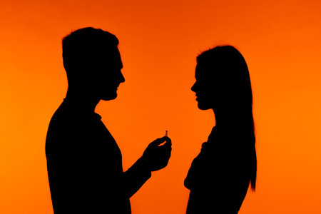 Silhouette of a couple in romantic proposal with ring
