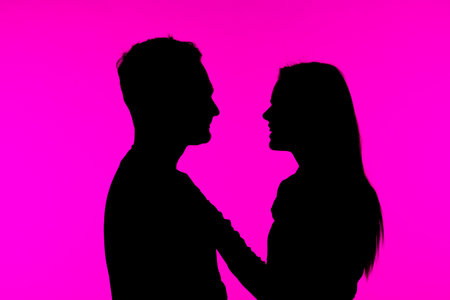 Silhouette of a Couple Against a Bright Pink Backgroundの写真素材