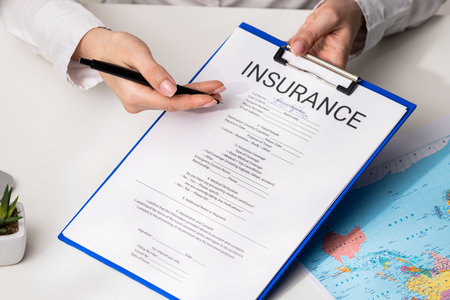 Filling Out Insurance Document at Desk with Map