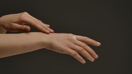 Hands Applying Moisturizing Lotion on Skin Surface Carefullyの写真素材