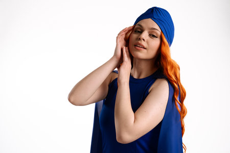 Woman in Blue Outfit and Headscarf with Orange Hair Posingの写真素材