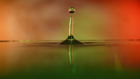 Close-up Slow Motion Of Dripping Water Scene Against Color Backgroundの写真素材