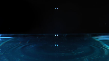 Close-up Slow Motion Of Dripping Water Scene Against Black Background