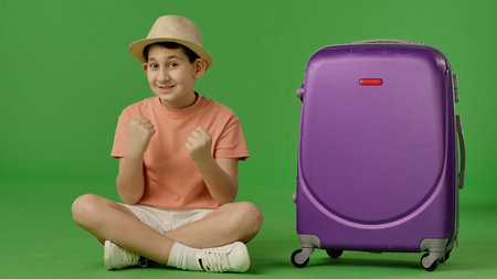 Cheerful Traveler with Large Purple Suitcaseの写真素材