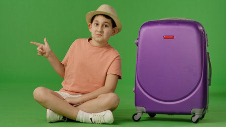 Young Traveler with Purple Suitcase on Green Backgroundの写真素材