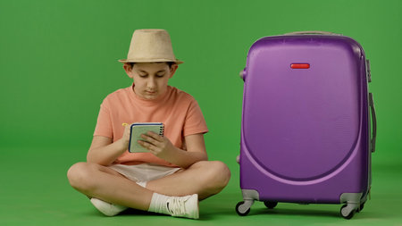 Child with Purple Suitcase on Green Backgroundの写真素材