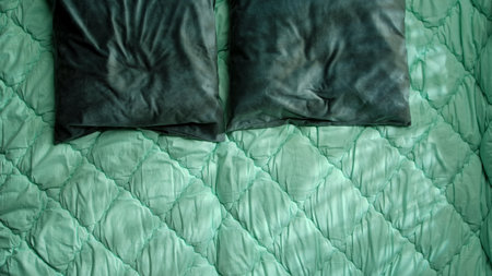 Textured Green Bedspread with Dark Green Pillows in Bedroom