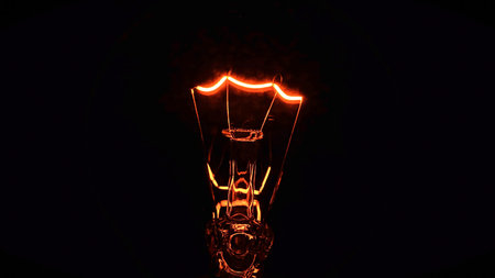 Glowing tungsten filament inside a vintage incandescent bulb