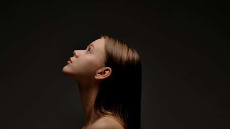 Profile View of Woman Against Dark Backgroundの写真素材