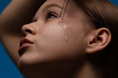 Close-up of skincare serum application on young womans faceの写真素材