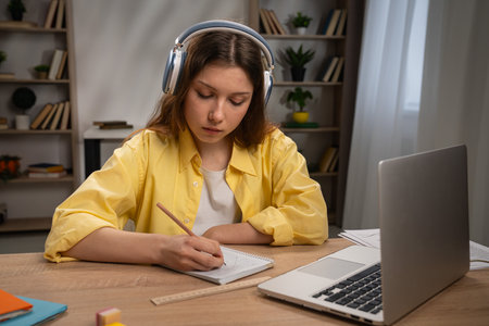 Young Girl Studying at Desk in Cozy Room with Headphones