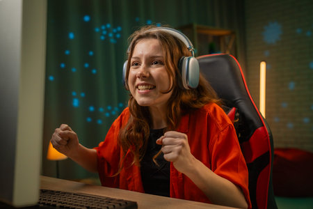 Excited Gamer Woman Wearing Headphones Celebrating Victoryの写真素材