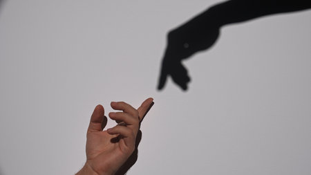 Human Hand Reaching Towards a Shadowの写真素材