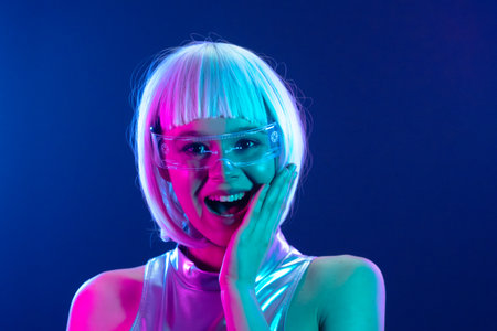 Pleasantly surprised futuristic woman in neon lights with smart glassesの写真素材
