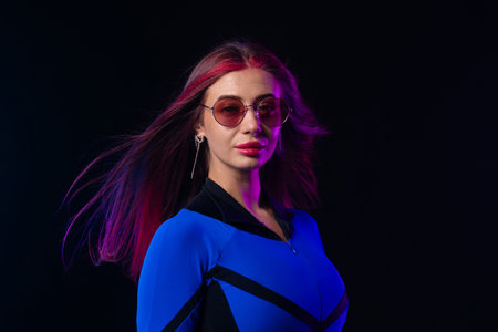 Stylish futuristic woman in blue bodysuit and sunglassesの写真素材