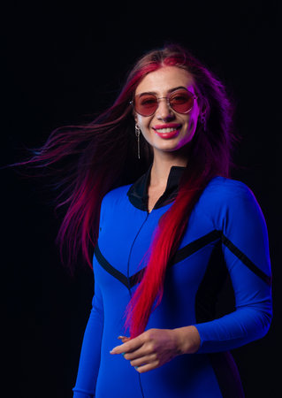 Stylish futuristic woman in blue bodysuit and sunglasses
