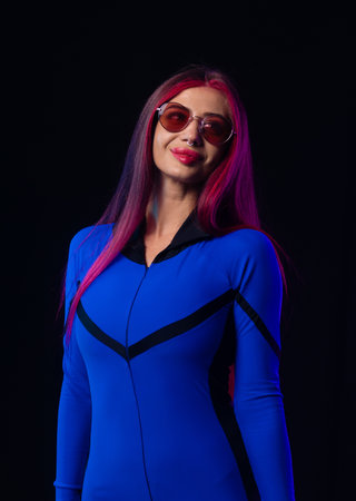 Stylish futuristic woman in blue bodysuit and sunglasses