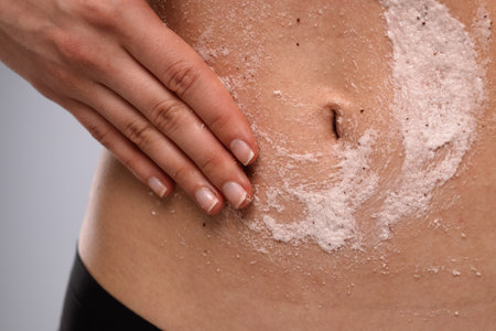 Hand Applying Exfoliating Scrub on Skin for Smoothnessの写真素材