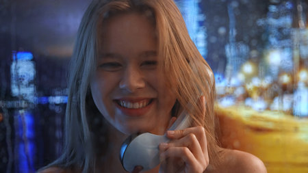 Smiling Woman Talking on Phone On A Rainy Nightの写真素材