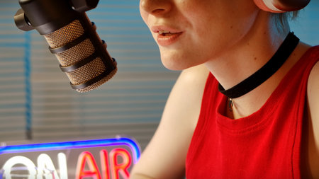 Close-up of Female Radio Host Using Microphone for Podcast Recordingの写真素材