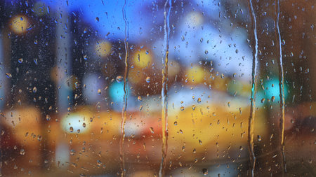 Colorful city lights through rainy window glassの写真素材