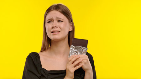 Woman Holding Chocolate Bar with Distressed Expressionの写真素材