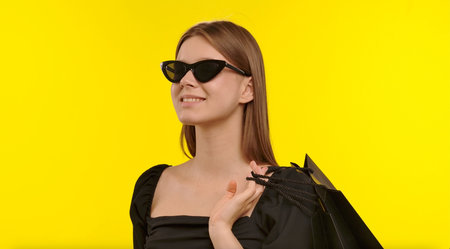 Smiling Woman Wearing Sunglasses Holding Shopping Bagsの写真素材